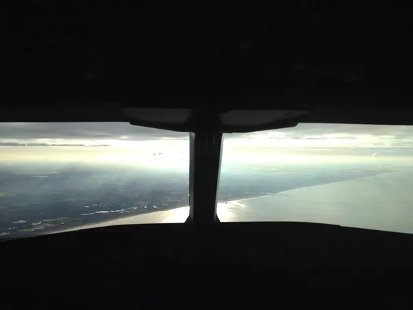 Left of the cockpit window divider: the high-rises of The Hague. Just to the right of the divider: the Pier of Scheveningen, further right the entrance to Scheveningen harbor, and far right in the distance: Hoek van Holland and the Rotterdam Maasvlakte.